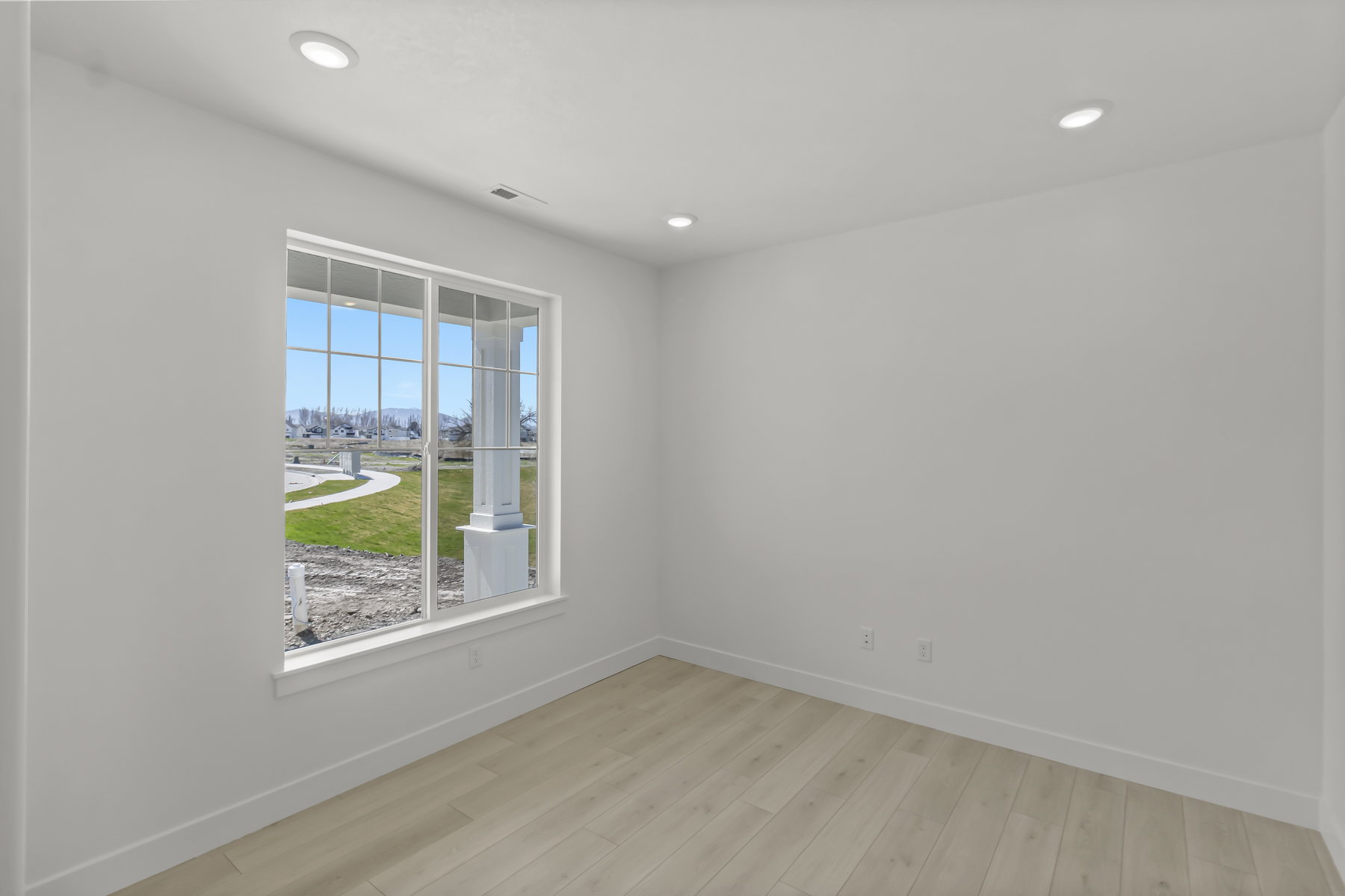 Interior space featuring light wood-finish flooring, white walls, and recessed lighting