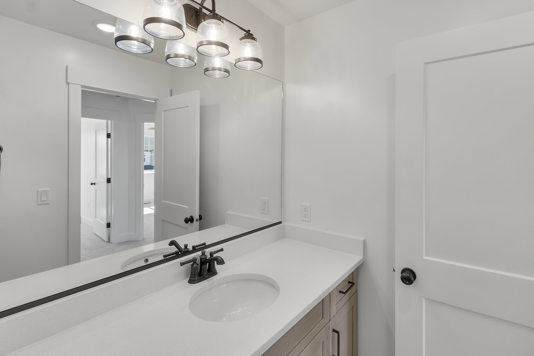 Bathroom vanity with a white solid surface countertop and undermount sink