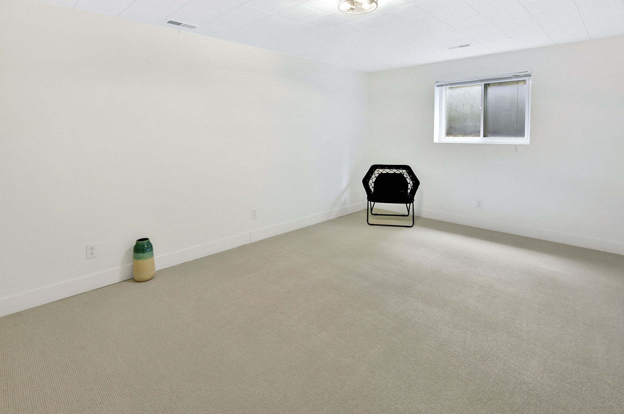 Spacious room with light-toned carpeting and neutral white walls