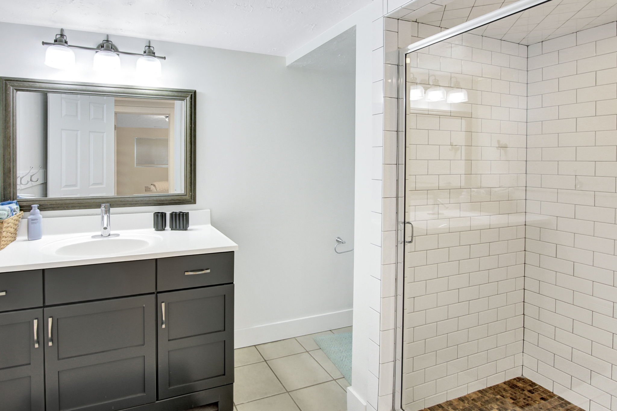Bathroom featuring a dark wood vanity with a white countertop, an oval undermount sink, and a framed mirror