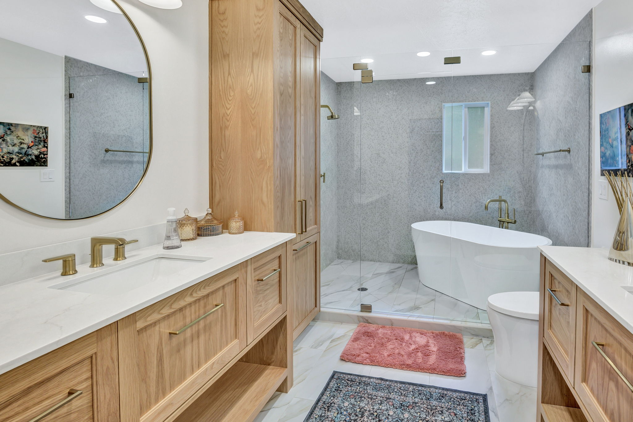 Bathroom featuring dual wood-finish vanities with white countertops and undermount sinks
