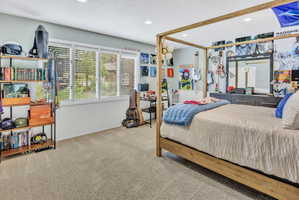 Spacious room featuring light-toned carpet flooring and a multi-panel window with white blinds