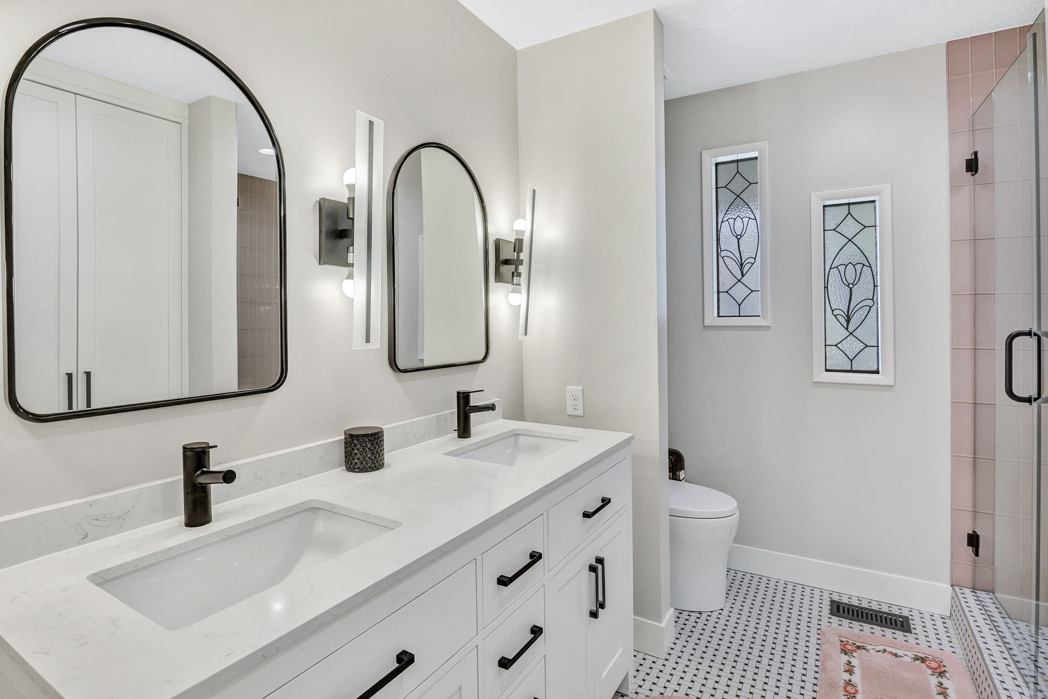 Double vanity featuring quartz countertops, undermount sinks, and matte black fixtures