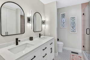 Double vanity featuring quartz countertops, undermount sinks, and matte black fixtures