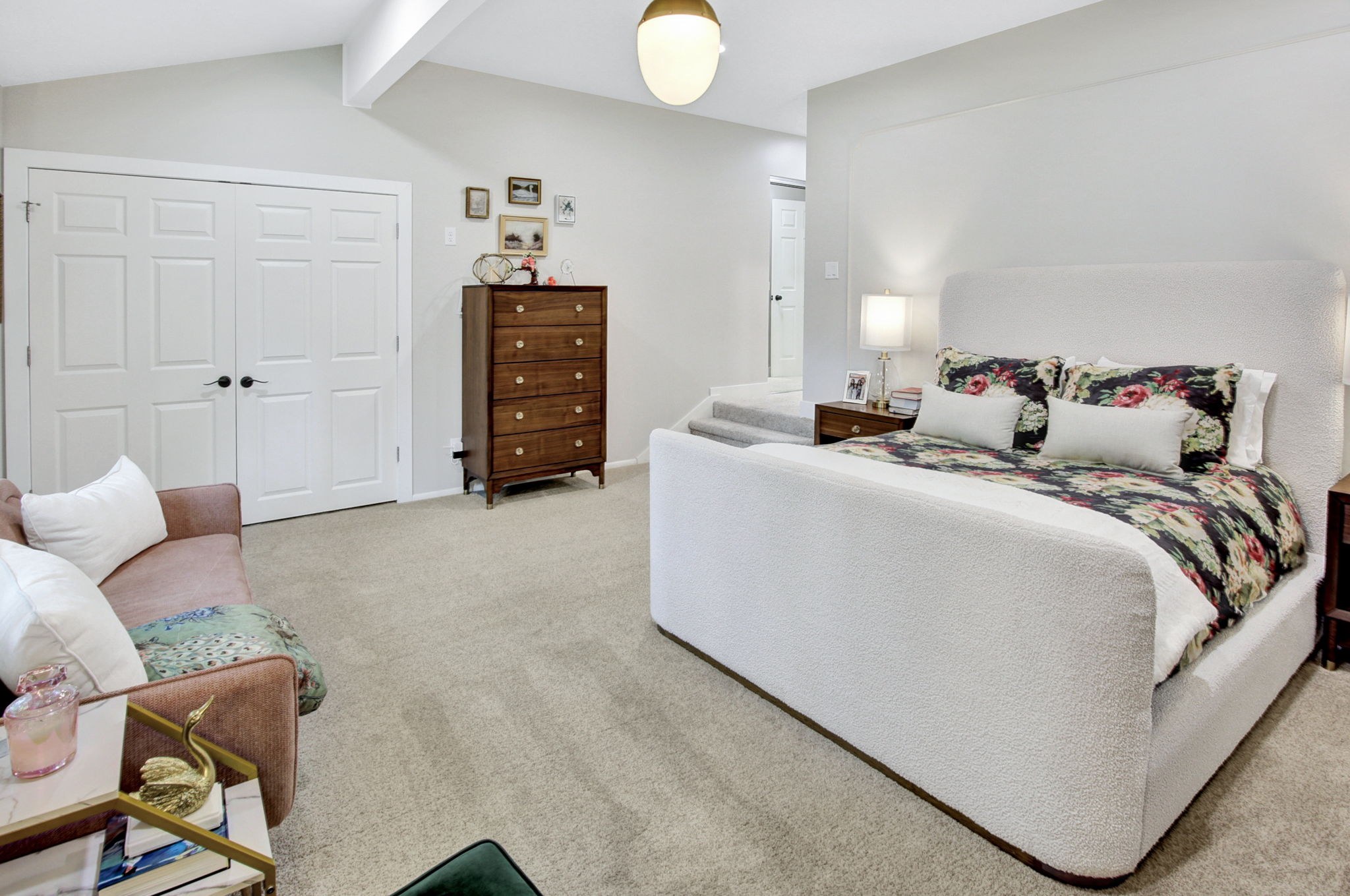 Carpeted bedroom with vaulted ceilings, recessed lighting, and a prominent pair of white panel doors