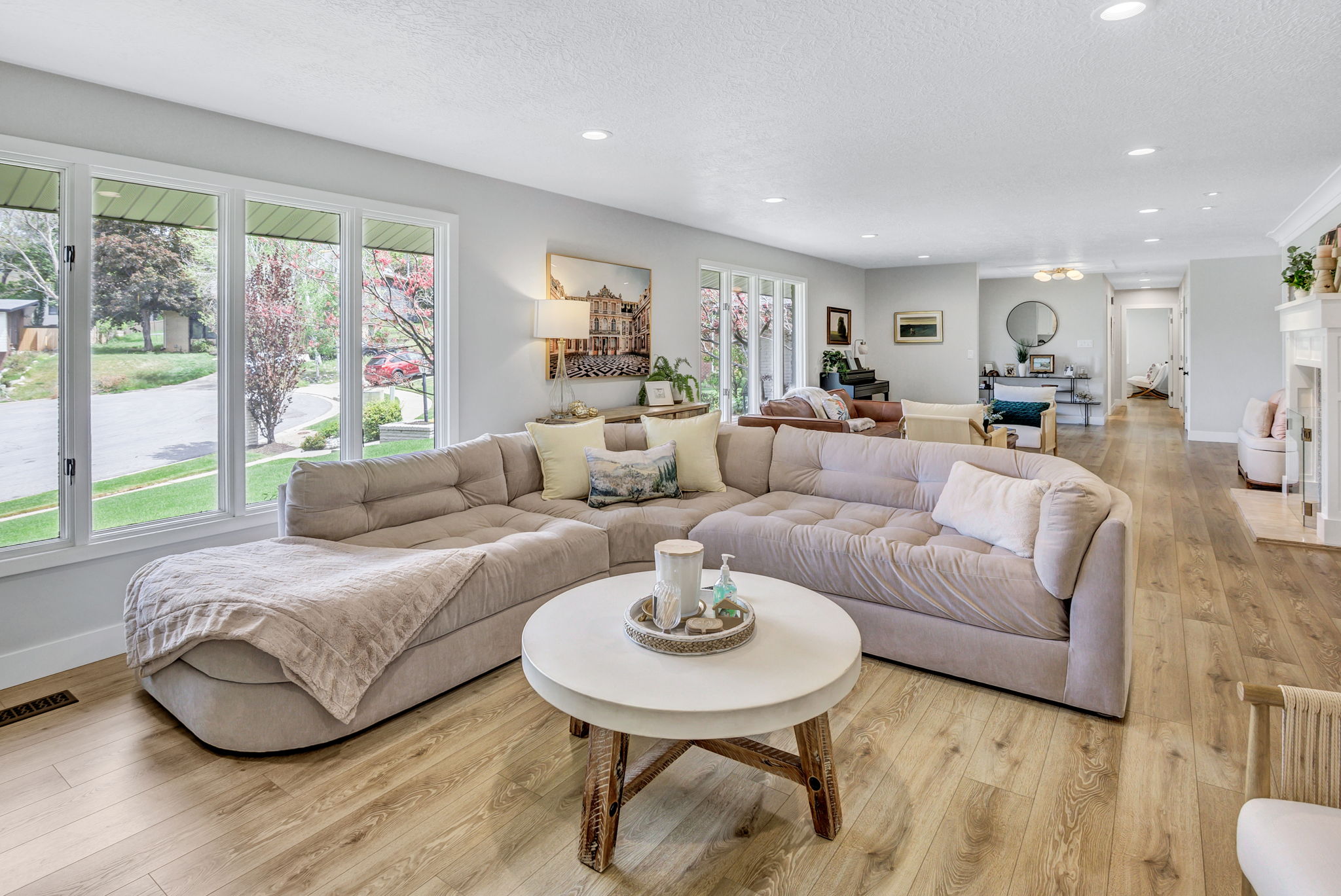 Living area featuring expansive windows, recessed lighting, wood-finish flooring, and a white fireplace with a decorative mantel