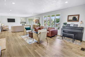 Expansive living area featuring light wood-finish flooring and recessed ceiling lights throughout