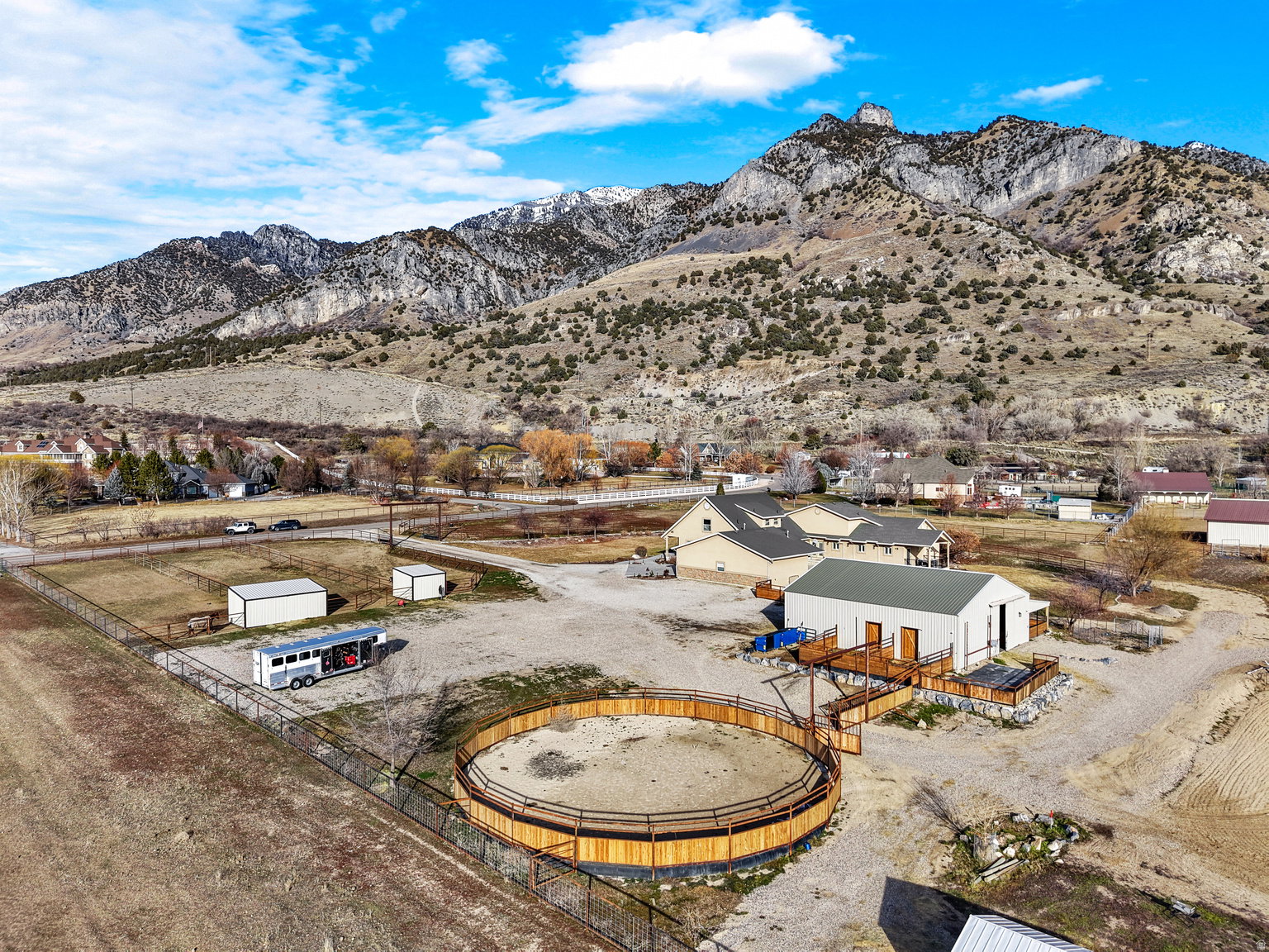 Expansive property featuring a circular fenced arena, multiple outbuildings, and a large primary residence