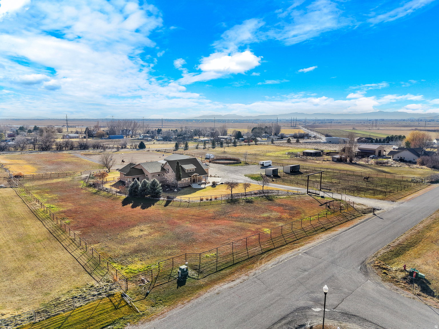 Expansive property featuring a large residence, surrounding grounds, and distant mountain ranges