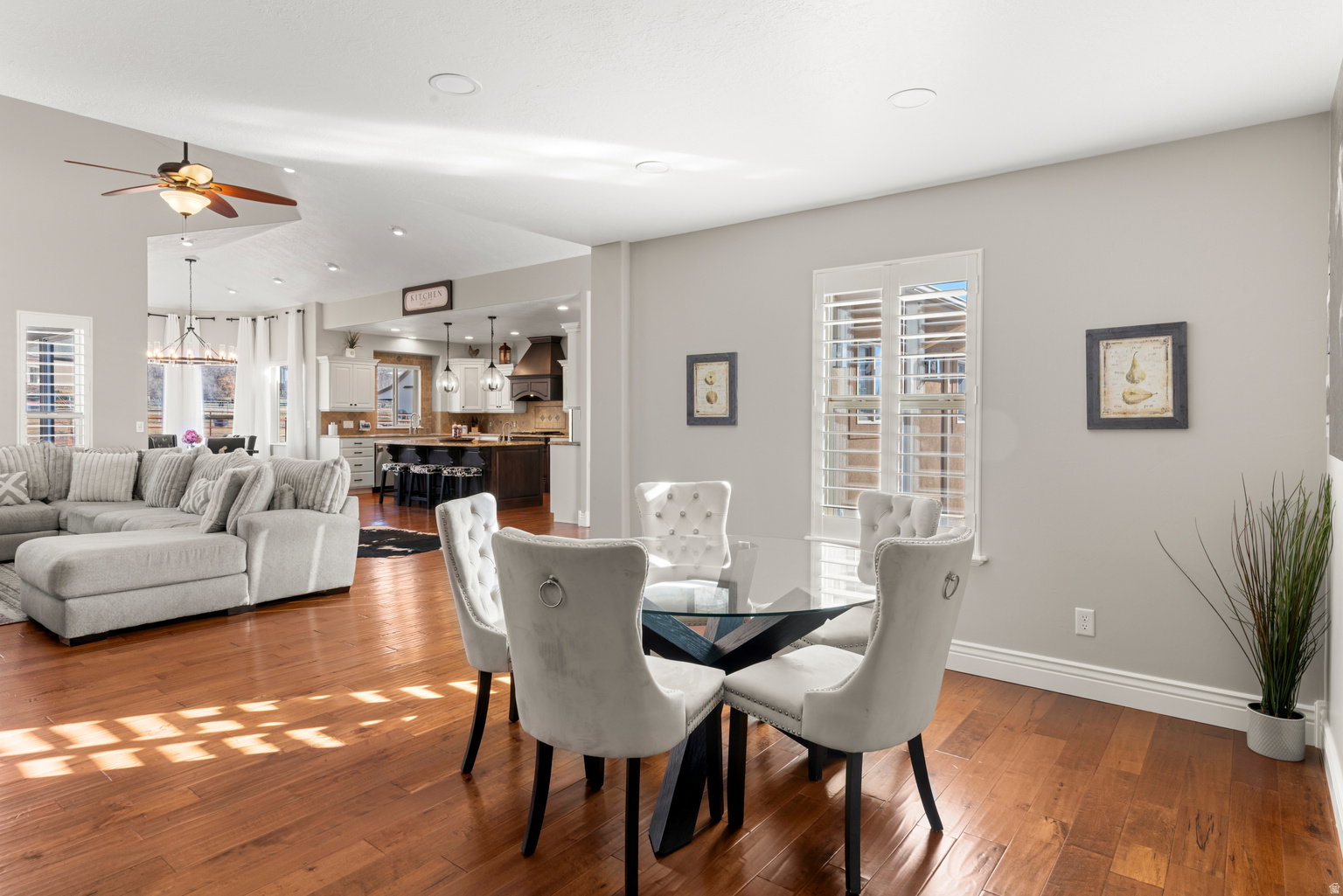 Open-concept living space featuring wood-finish flooring, recessed lighting, and white plantation shutters