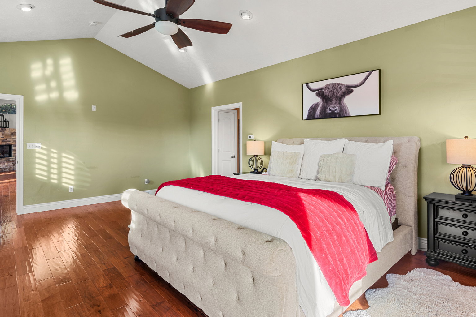 Spacious room featuring vaulted ceilings, wood-finish flooring, and recessed lighting