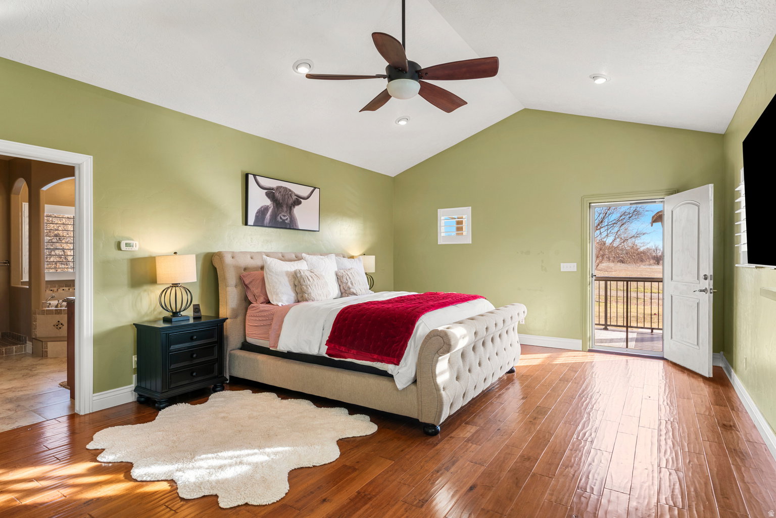 Vaulted ceiling featuring a ceiling fan, recessed lighting, wood-finish flooring, and direct access to an outdoor balcony with metal railings