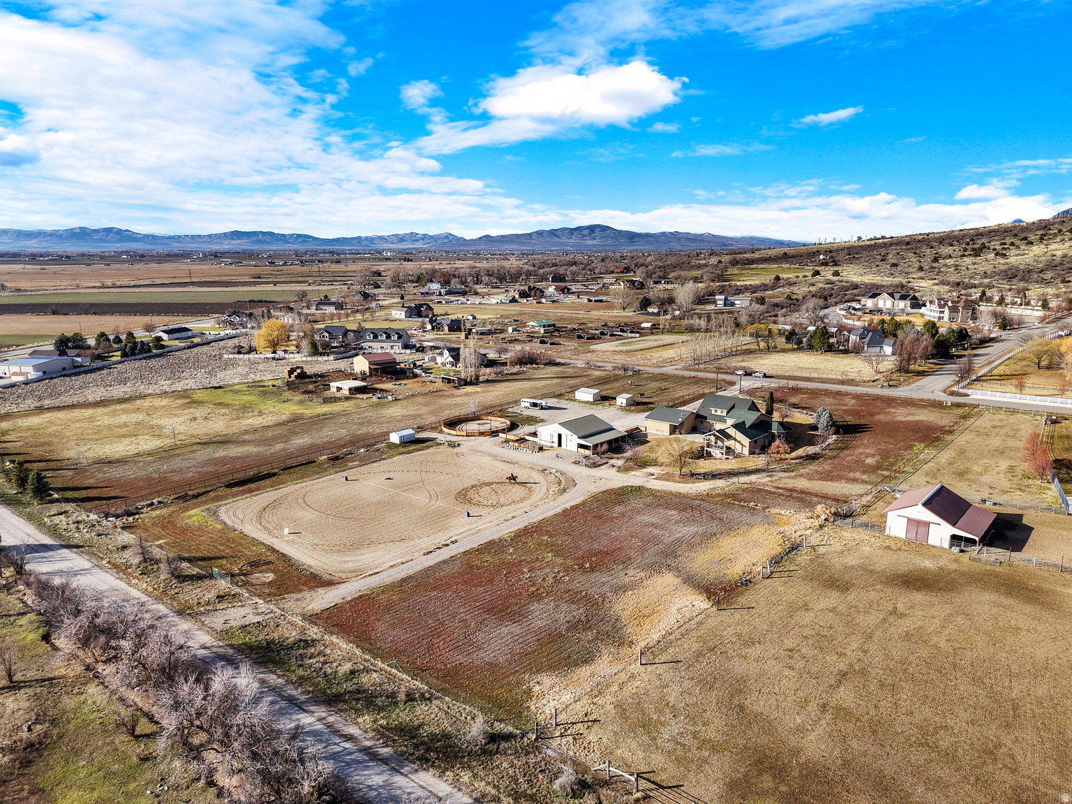 Expansive property featuring an outdoor riding arena, multiple outbuildings, and a main residence with a green roof