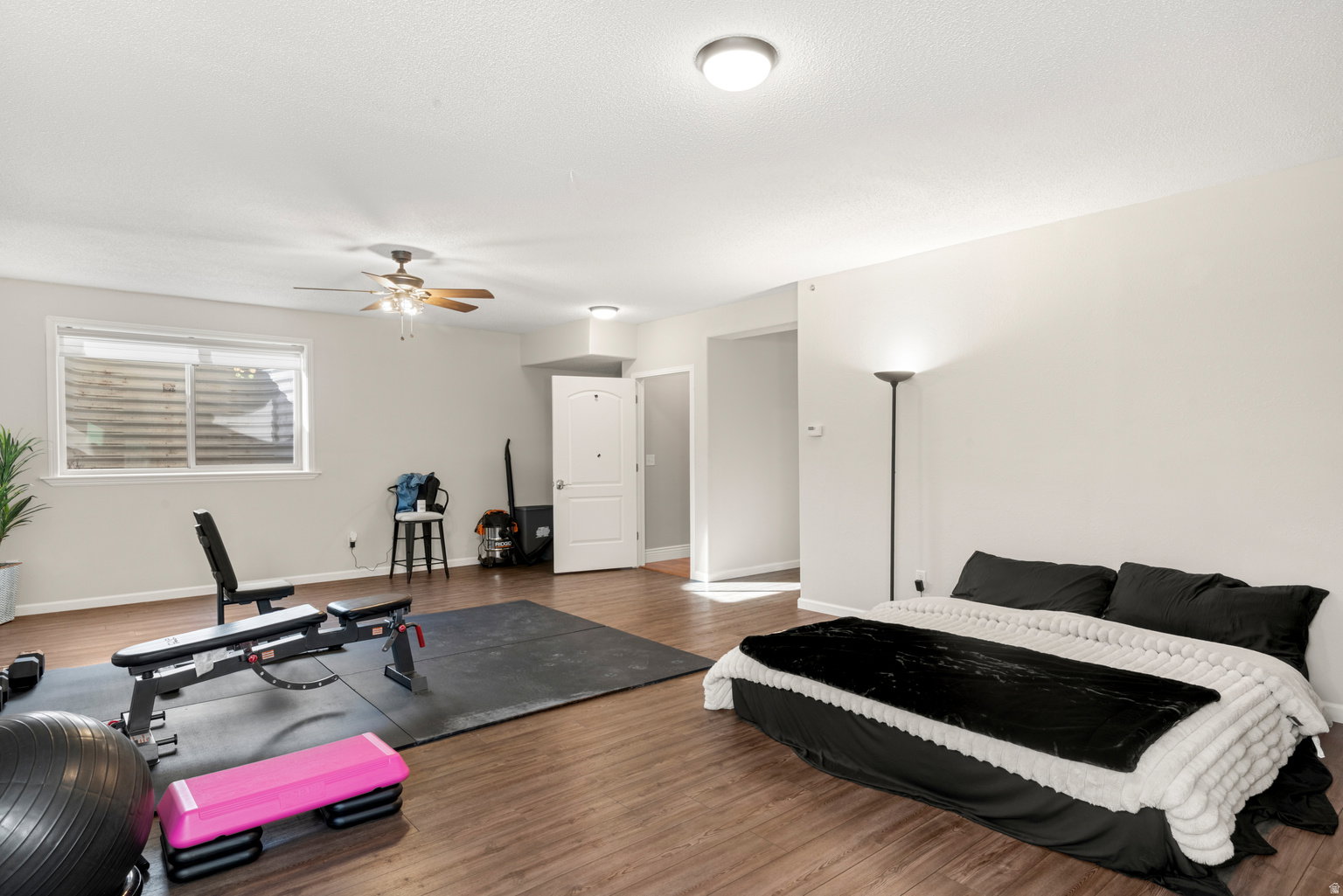 Spacious room with wood-finish flooring, a ceiling fan, and recessed lighting