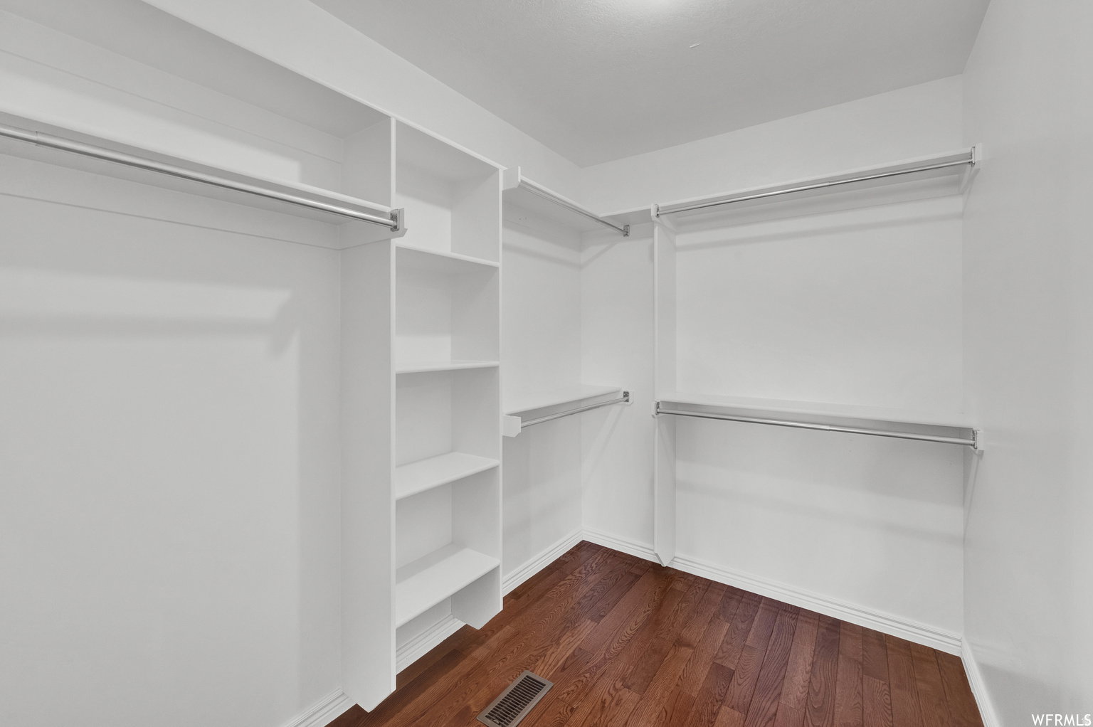 Custom closet system featuring white shelving and chrome hanging rods