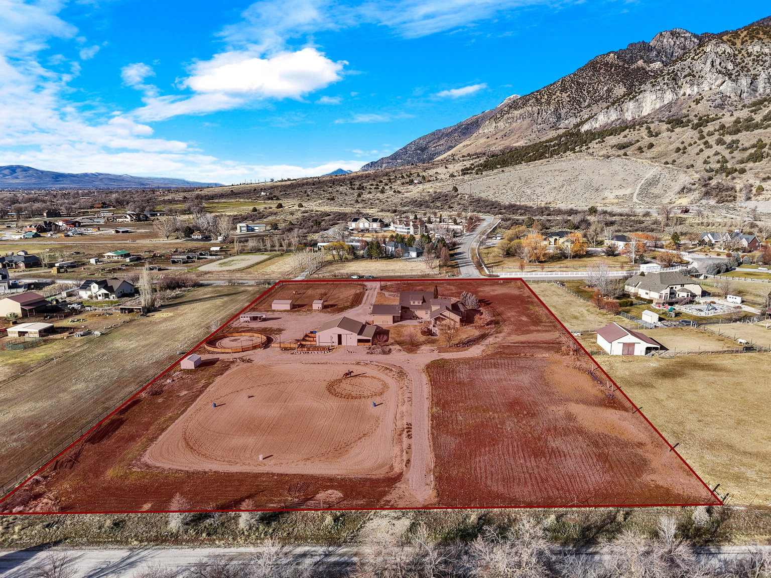 Expansive property featuring multiple structures, a large graded area, and a circular pen
