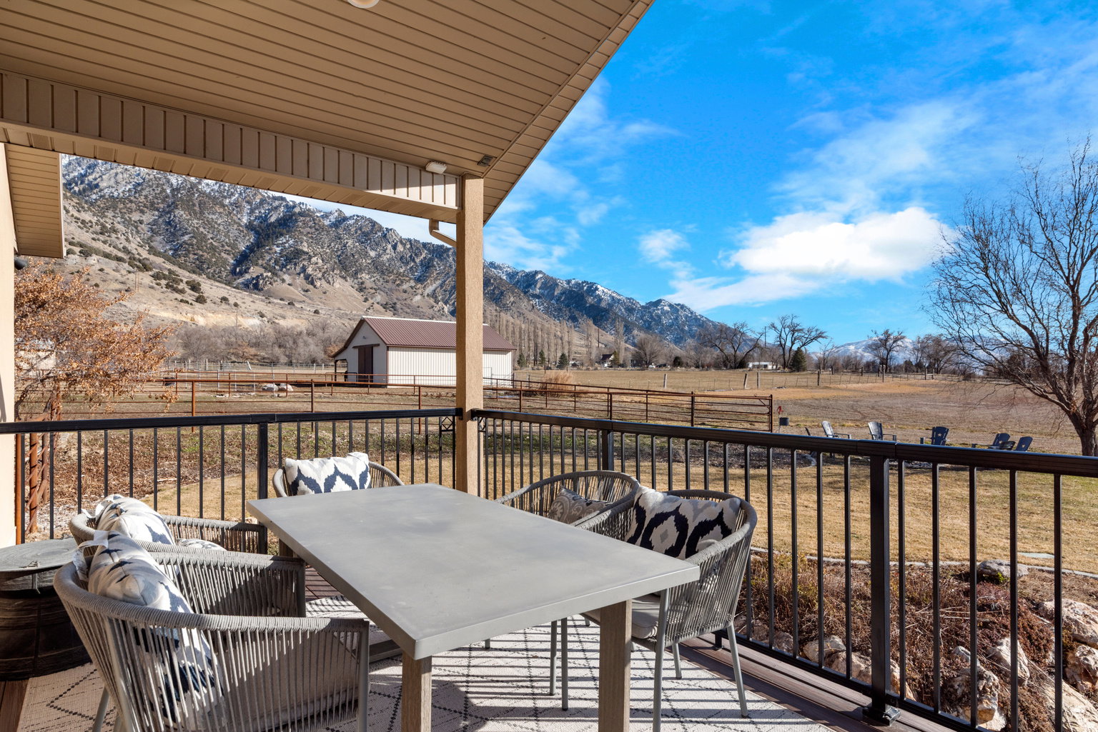 Covered outdoor deck with composite decking and black metal railings