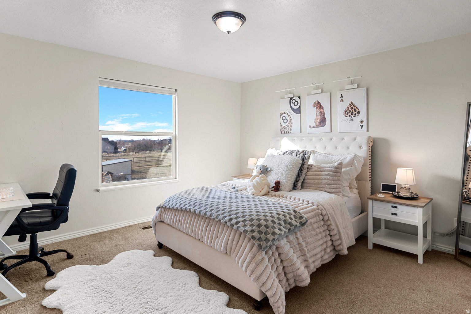 Light-colored walls and tan carpeting define this space, featuring a single window