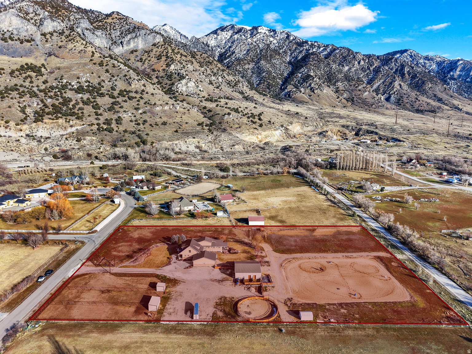 Expansive rural property featuring multiple structures, a round pen, and a large arena