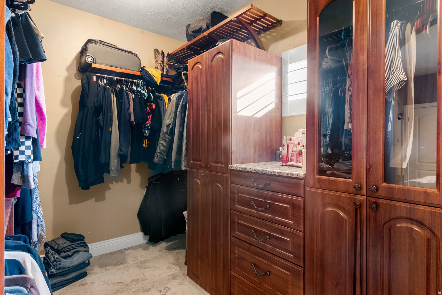 Custom closet system featuring wood-finish cabinetry and integrated shelving