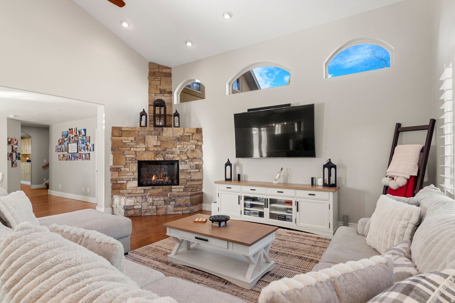 Vaulted ceilings highlight a corner stone-faced fireplace with hearth