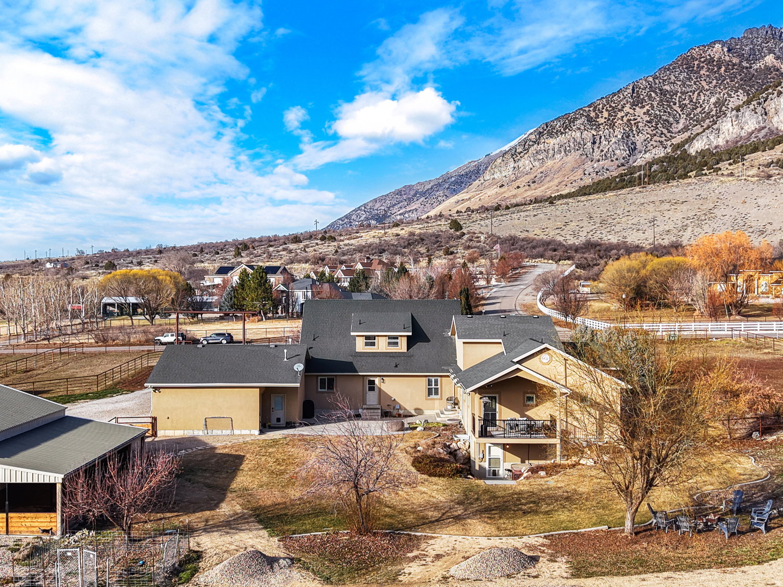 Expansive property featuring a multi-level dwelling with a ground-level patio and an upper-level balcony