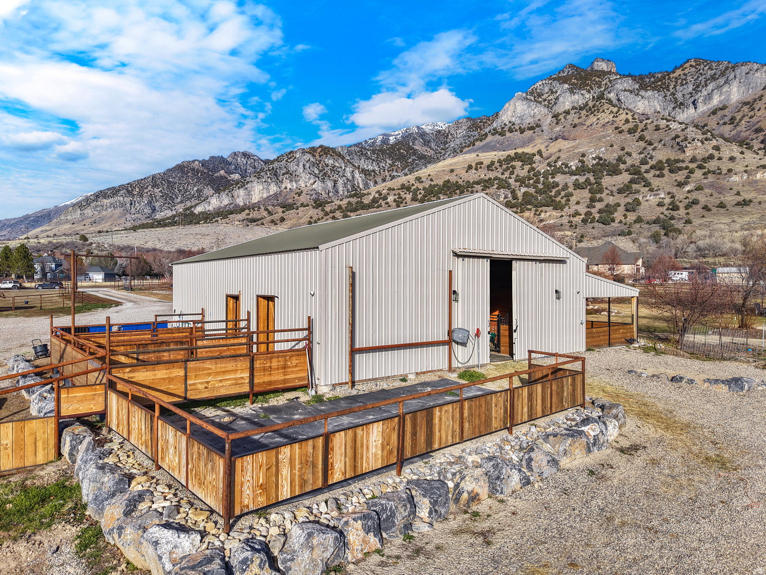 Metal-sided barn featuring a sliding door entry and a covered exterior stall