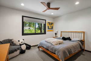 Carpeted room with a black-framed window, recessed lighting, and a wood-finish ceiling fan