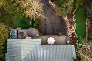 Rear outdoor living space featuring a built-in hot tub, spacious decking, and a putting green