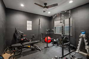 Dedicated fitness space featuring black walls, recessed lighting, a ceiling fan, a window with horizontal blinds, and durable rubber flooring