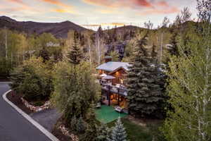 Multi-level property featuring wood-sided exterior, a covered deck, and a lower patio area