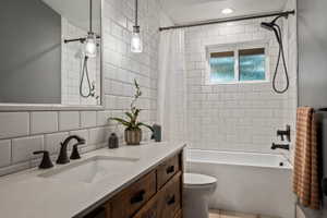 Bathroom featuring white subway tile surround, a built-in bathtub, and a window with frosted glass