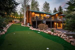 Expansive putting green with multiple holes, bordered by natural rock landscaping