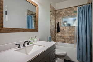 Bathroom featuring a dark wood-finish vanity with a light countertop, an undermount sink, and a dark bronze faucet