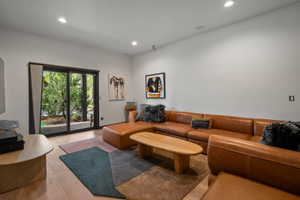 Spacious living area featuring light wood-finish flooring and recessed lighting