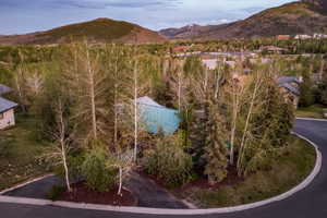 Property nestled among mature trees, featuring a distinctive turquoise roof
