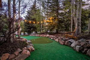 Putting green surrounded by natural rock landscaping and mature trees