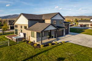 Contemporary two-story residence with a multi-textured facade featuring horizontal siding, vertical board and batten, and stone accents