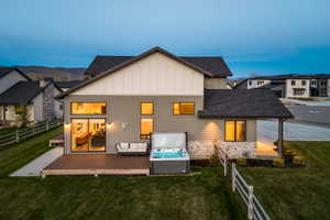 Modern multi-story residence featuring a wood-finish deck with an integrated spa