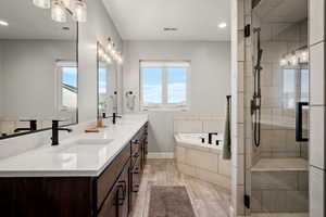 Dual vanity with integrated sinks and black fixtures, featuring a spacious countertop and dark wood-finish cabinetry
