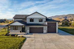 Modern two-story home featuring a combination of horizontal siding, vertical board and batten siding, and stone veneer accents
