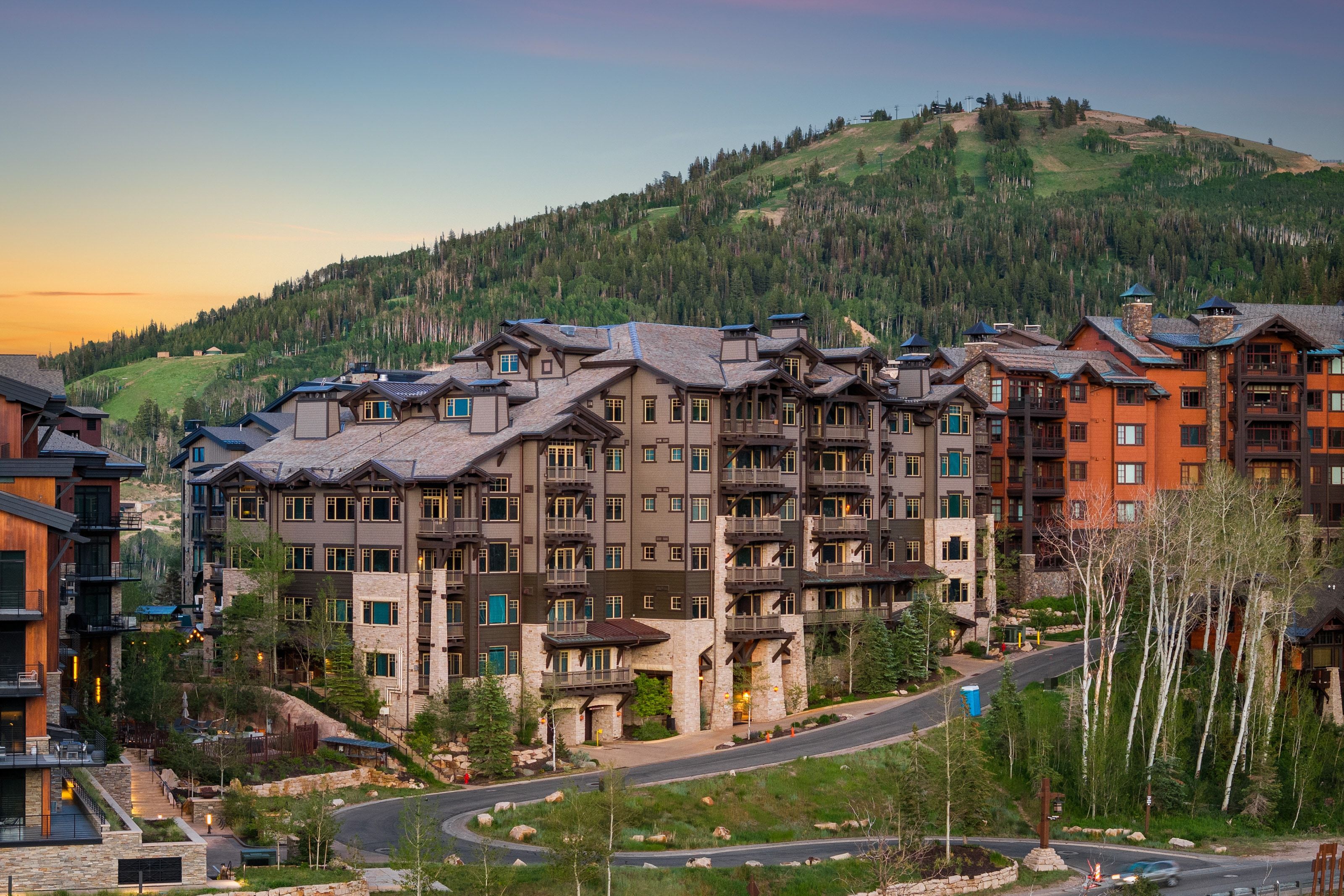 Multi-story mountain lodge architecture featuring stone and wood-paneled exteriors
