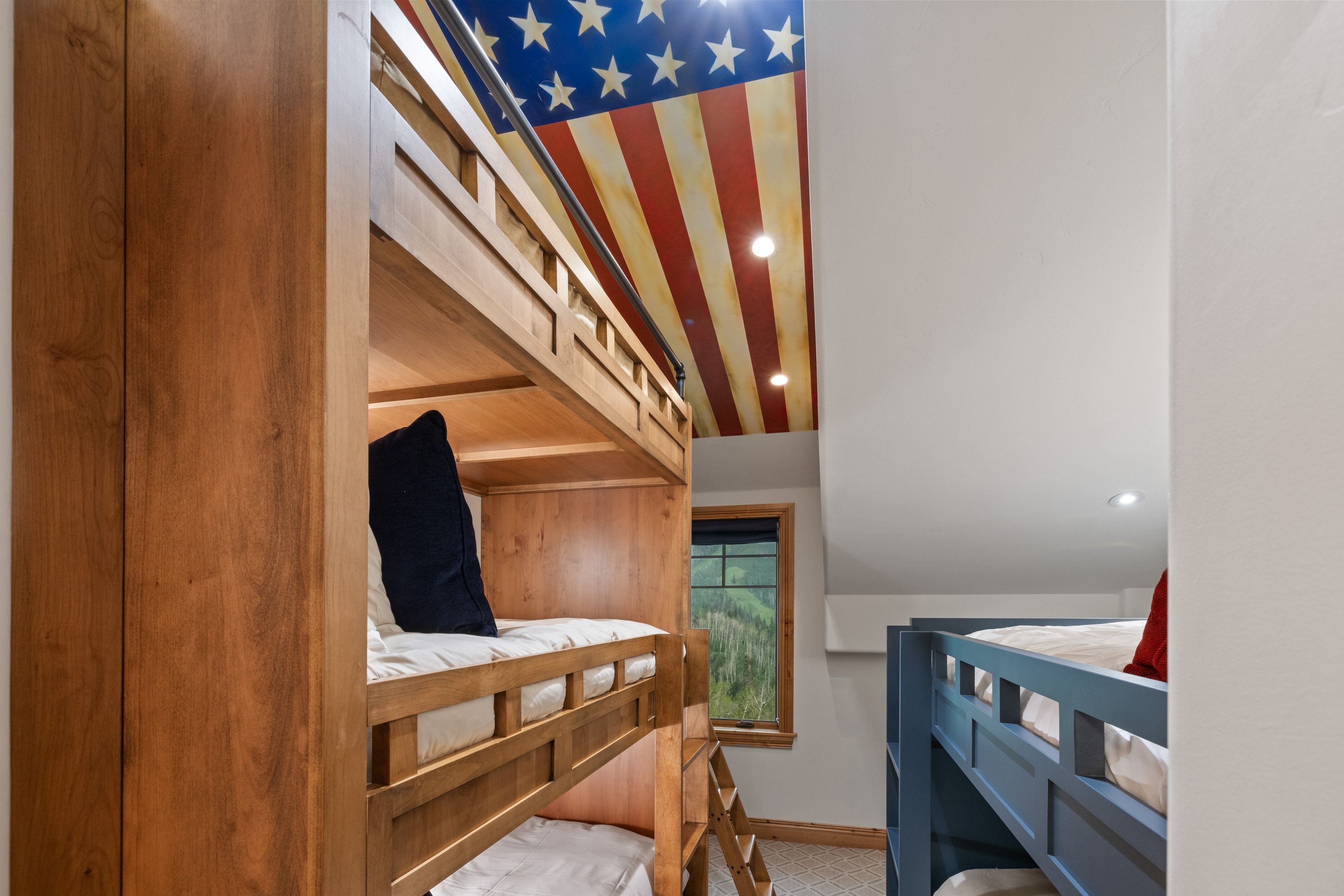 Custom bunk room featuring a sloped ceiling with a distinctive ceiling mural