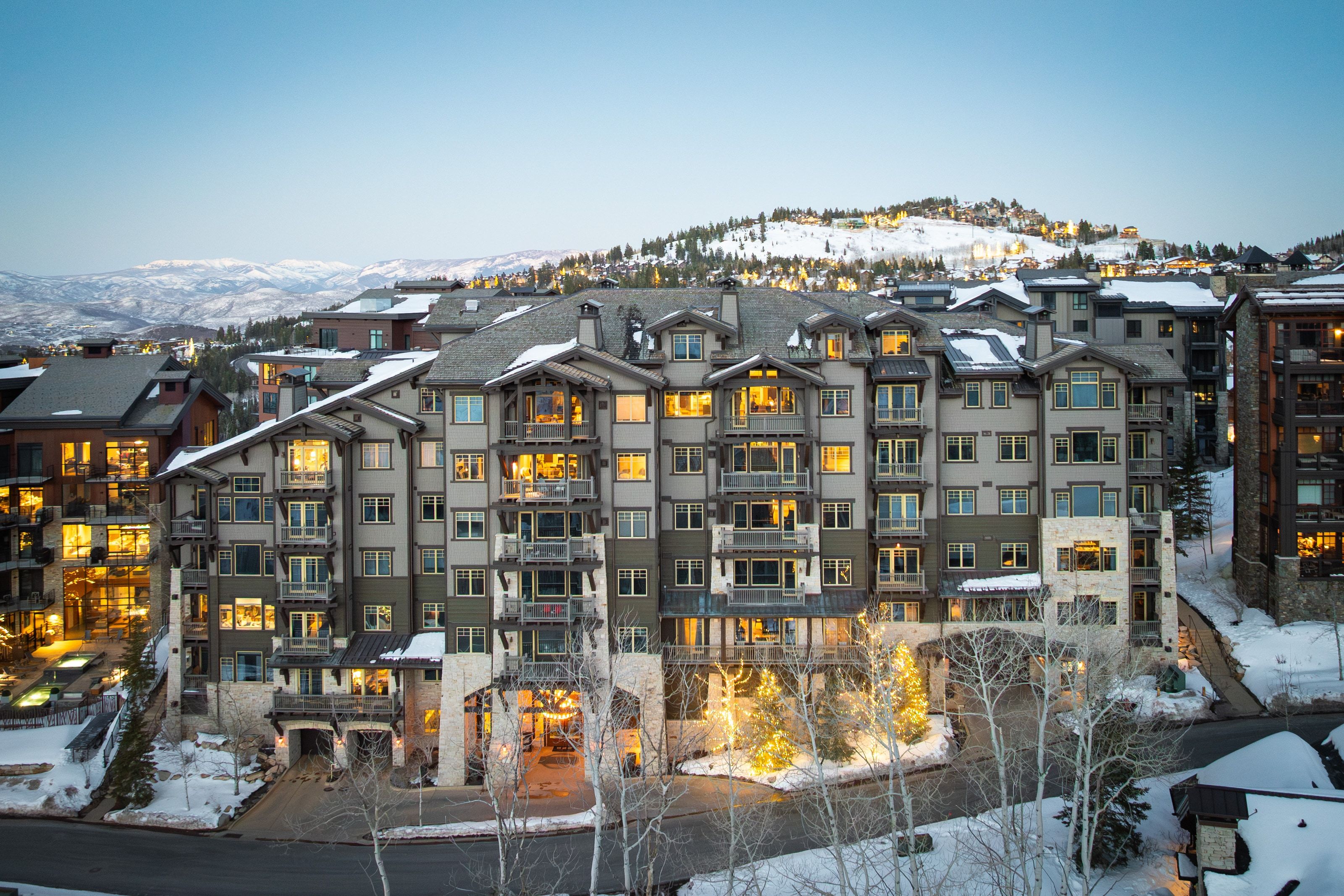 Multi-story building featuring stone and wood-finish siding with multiple balconies