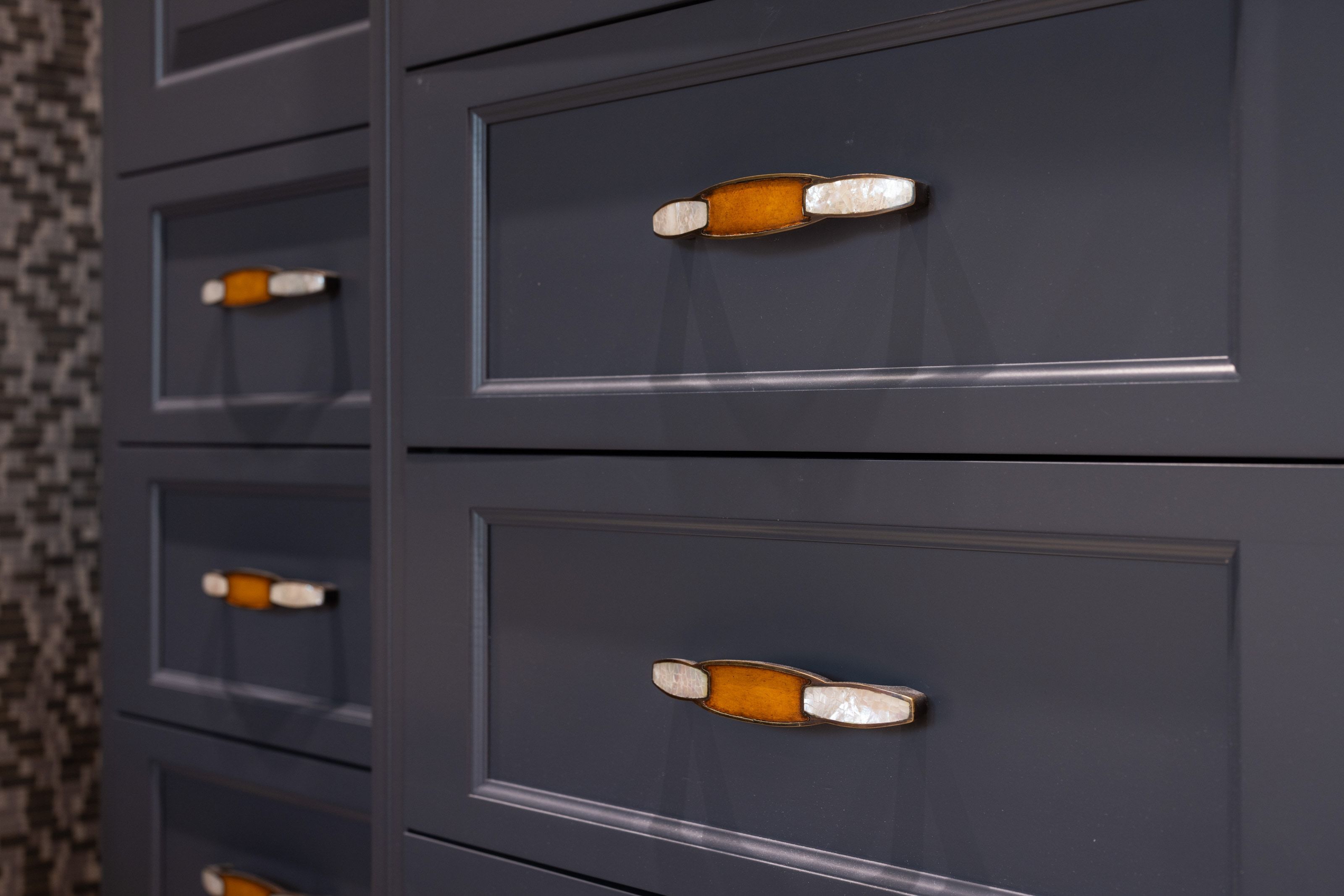 Navy blue cabinetry featuring recessed panel doors and drawers, accented with unique decorative hardware