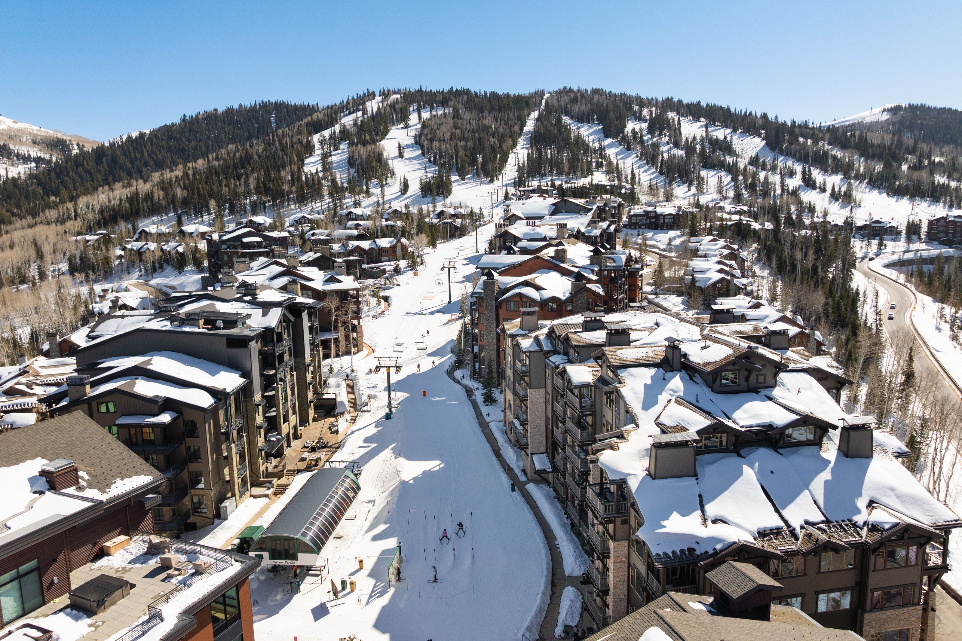 Slope-side residences featuring multi-story buildings with balconies, varied rooflines, and stone and wood-finish exteriors