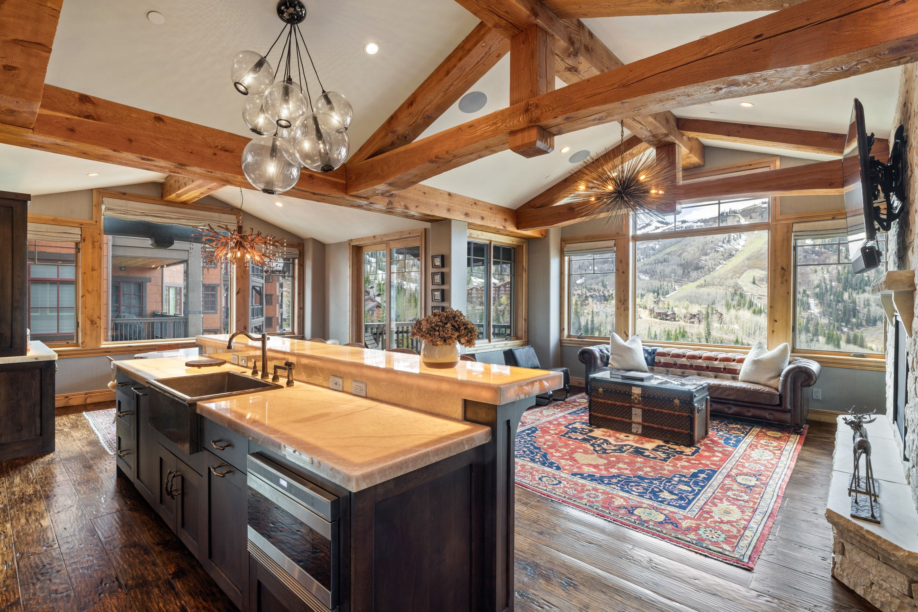 Vaulted ceilings with exposed wood beams define this open-concept room