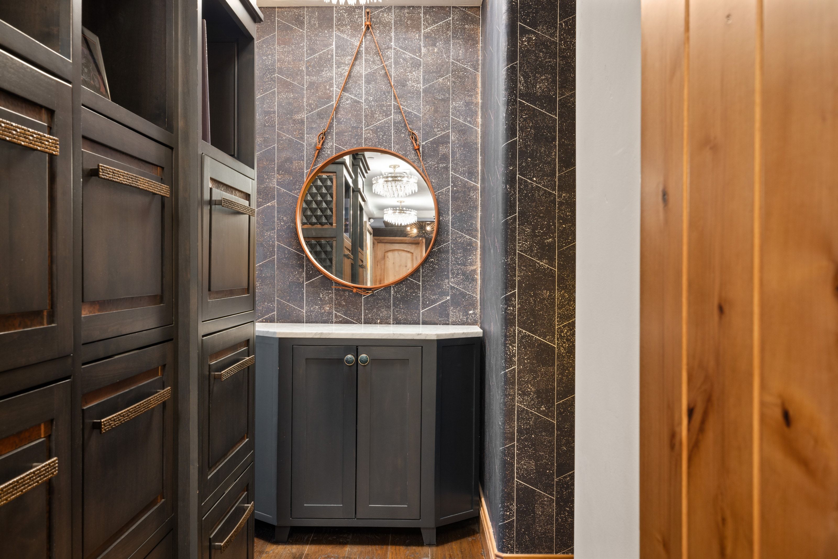 Corner vanity with a white countertop and dark cabinetry