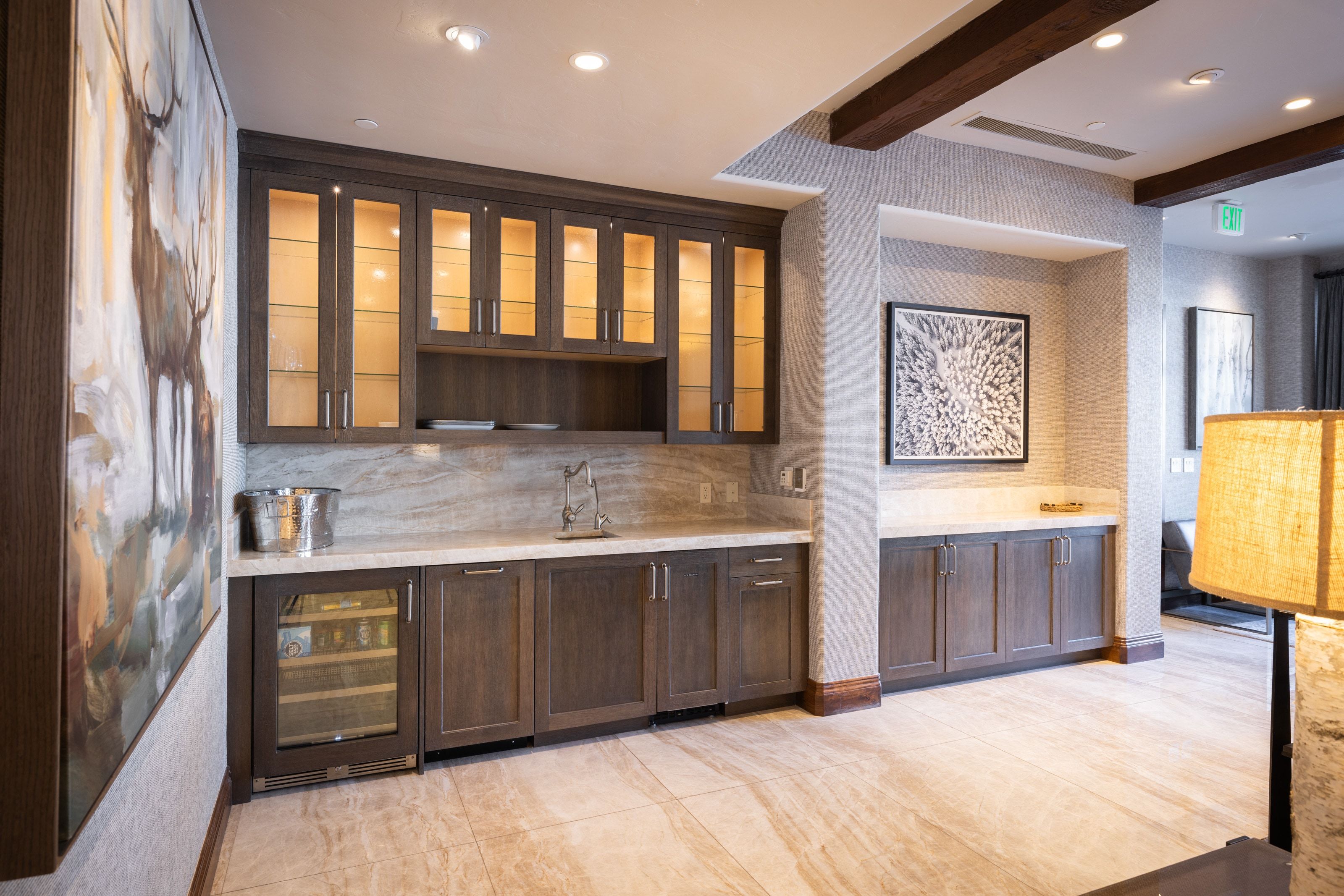 Built-in wet bar featuring dark wood cabinetry, integrated wine cooler, stone countertop, and matching stone backsplash