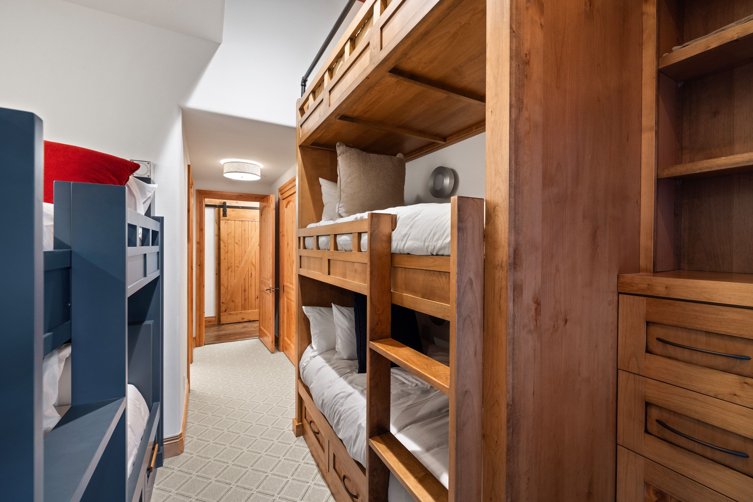 Dedicated bunk room featuring built-in wooden bunk beds, integrated shelving, and drawer storage